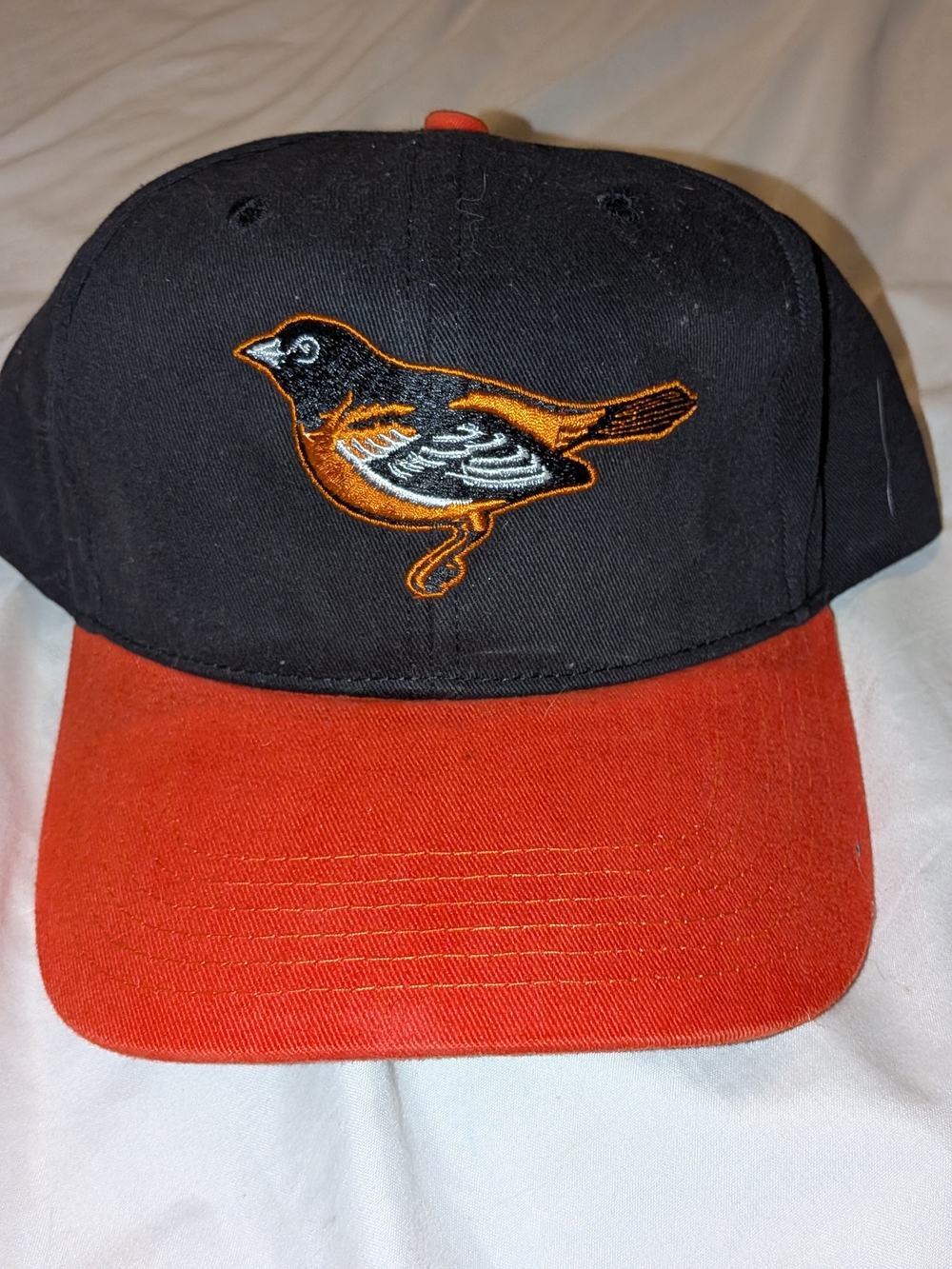 Genuine Merchandise Black and Orange Bird Logo Baseball Cap